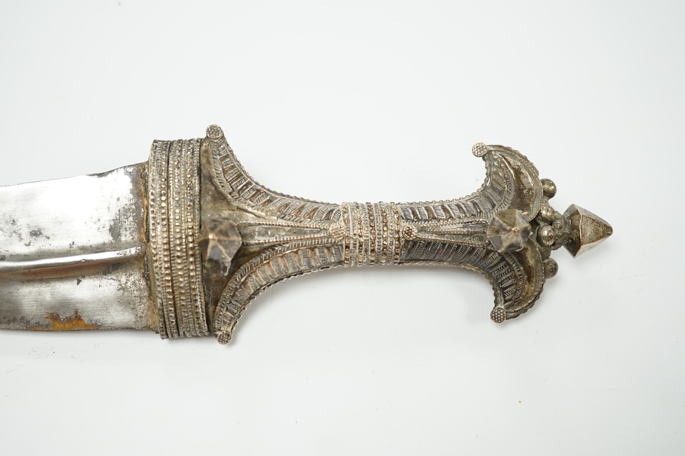 A composite Saudi dagger Jambiya c.1900, silver plated hilt, silver coloured metal sheath with engraved decoration. Condition - good, some wear